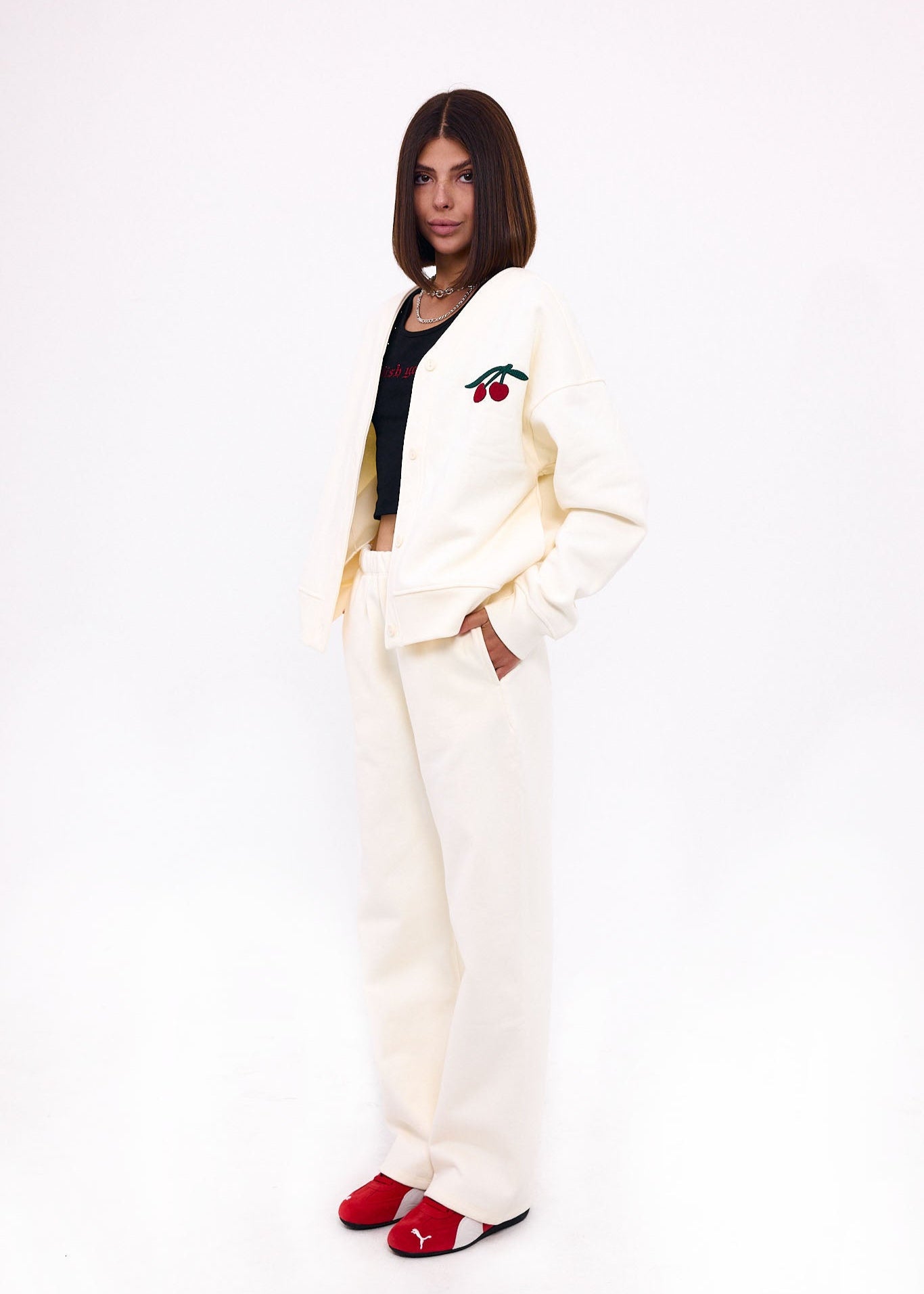 Person wearing a white fleece cardigan with matching pants on a white background