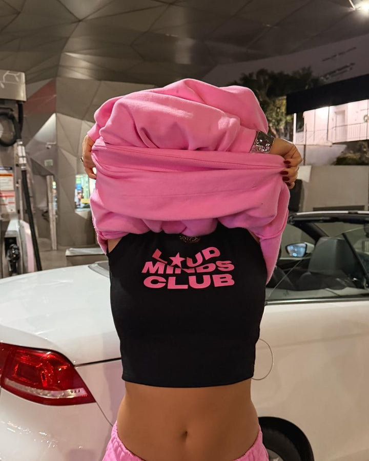 Loud Minds Club Baby Tee in black cropped cotton jersey with pink Loud Minds Club graphic, front view