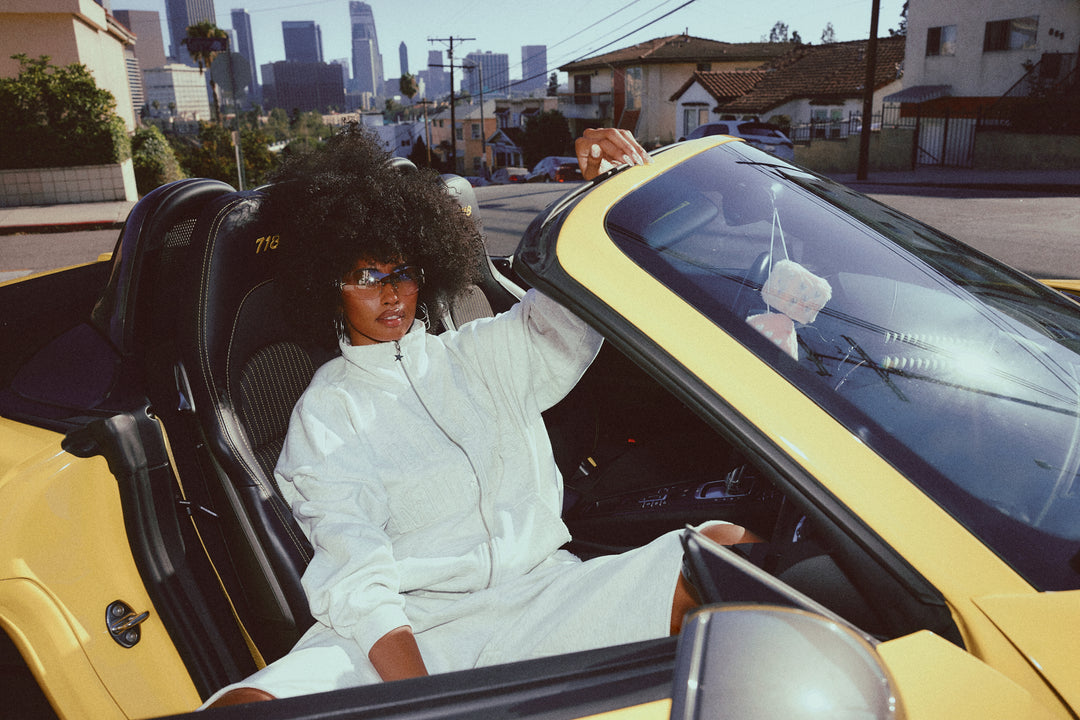 Person sitting in a yellow car with a cityscape in the background